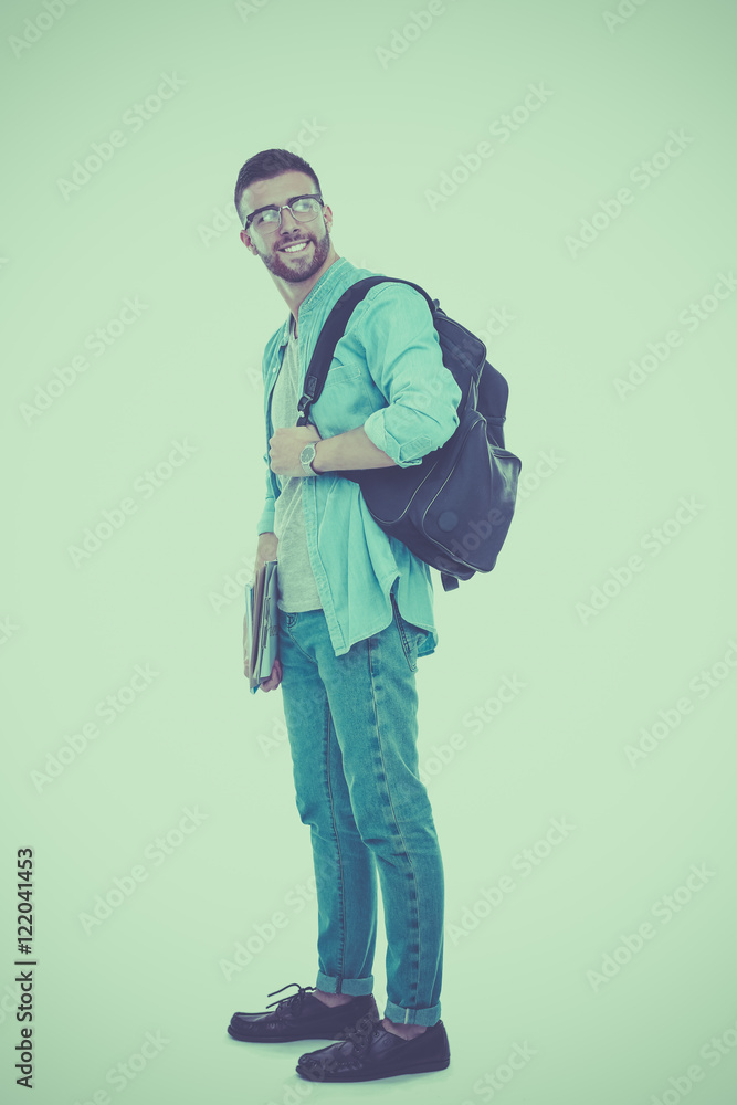 A male student with a school bag holding books isolated on white