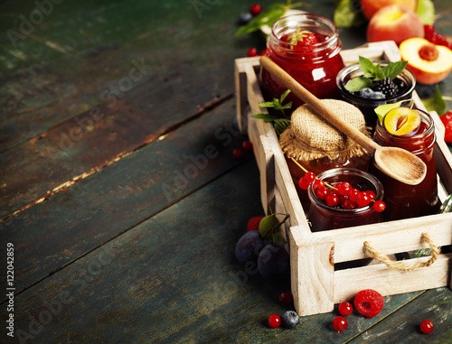 Fruit and berry jam on a wooden background