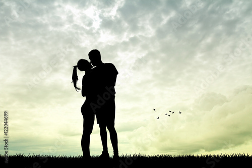 man and girl kissing at sunset