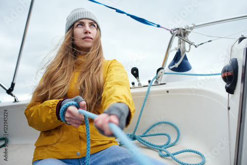 Young strong woman sailing the boat photo