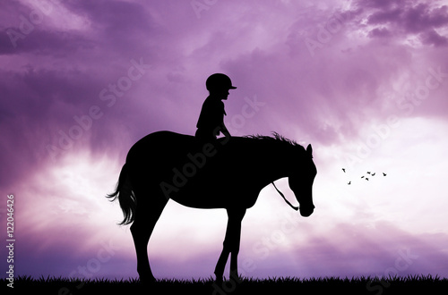 child on horseback at sunset