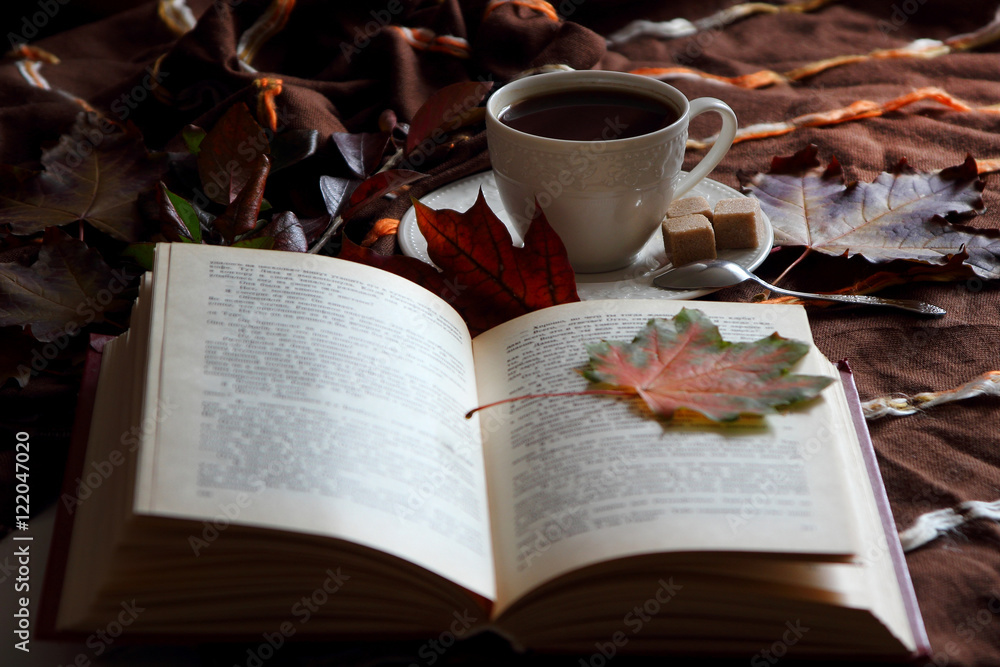 A cup of coffee on the background of an open book..