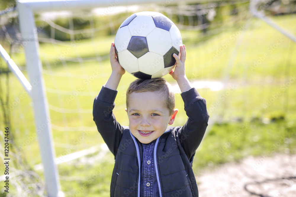 Naklejka premium boy with soccer ball in park