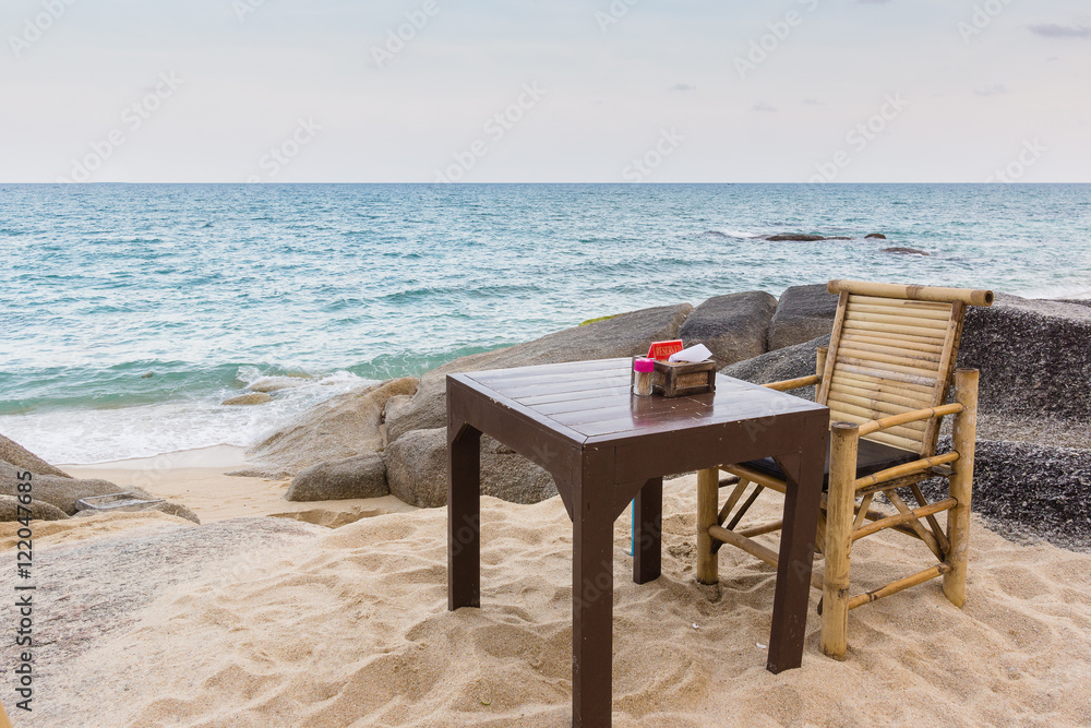 Table and chair on a rocky Thailand beach