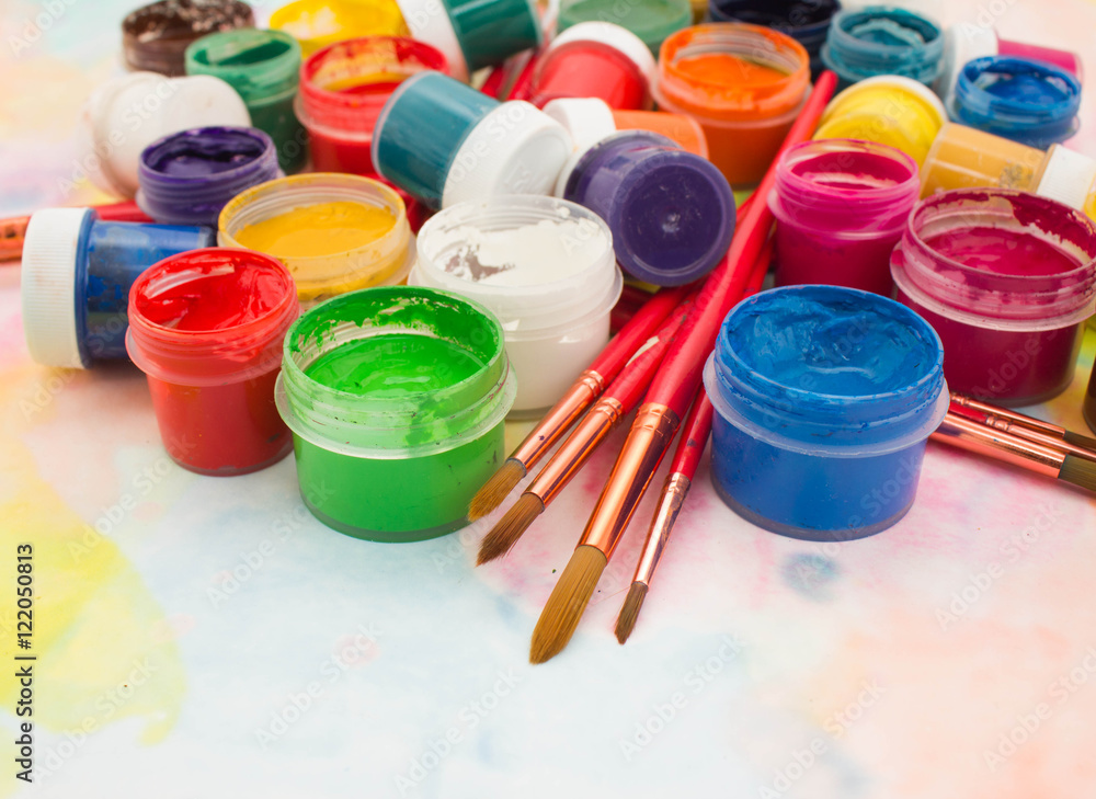 Paints, brushes and palette on the colorful background. The workplace of the artist. Banner for school Paints, brushes and palette on the colorful background. The workplace of the artist. Banner for school