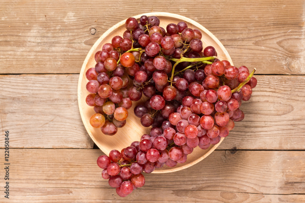 Red grapes on old wooden table Red grapes on old wooden table