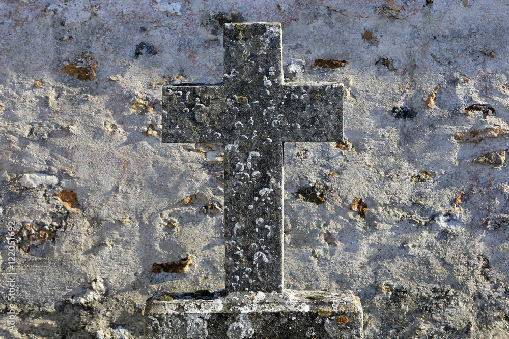 Croix en pierre sur une pierre tombale.