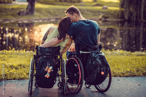  Handicapped young couple in wheelchairs in autumn park