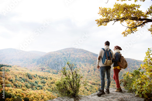 Photography Beautiful couple with backpacks against colorful autumn forest