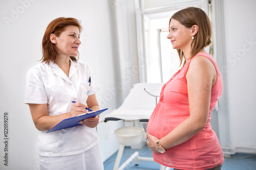 Nurse weighing pregnant woman in office