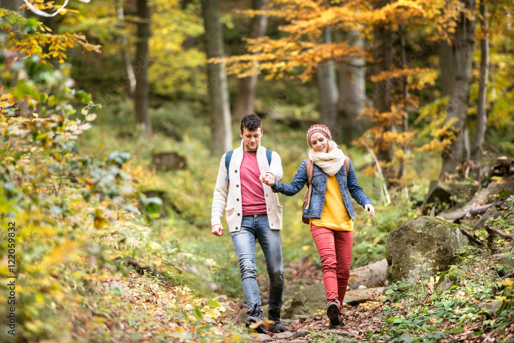 Beautiful couple on a walk in sunny autumn forest