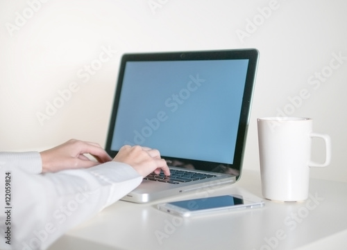 Worker woman working on laptop computer in office.