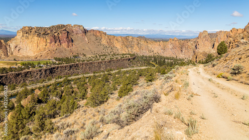 The road among the dry grass. The beautiful landscape of cliffs. Smith Rock state park, Oregon