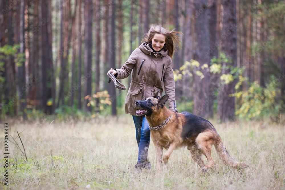 Young attractive woman playing with German Shepherd dog outdoors in the autumn park Young attractive woman playing with German Shepherd dog outdoors in the autumn park