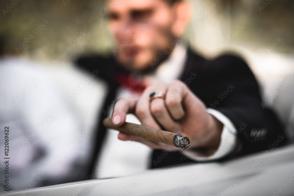 the groom in the car Smoking a cigar