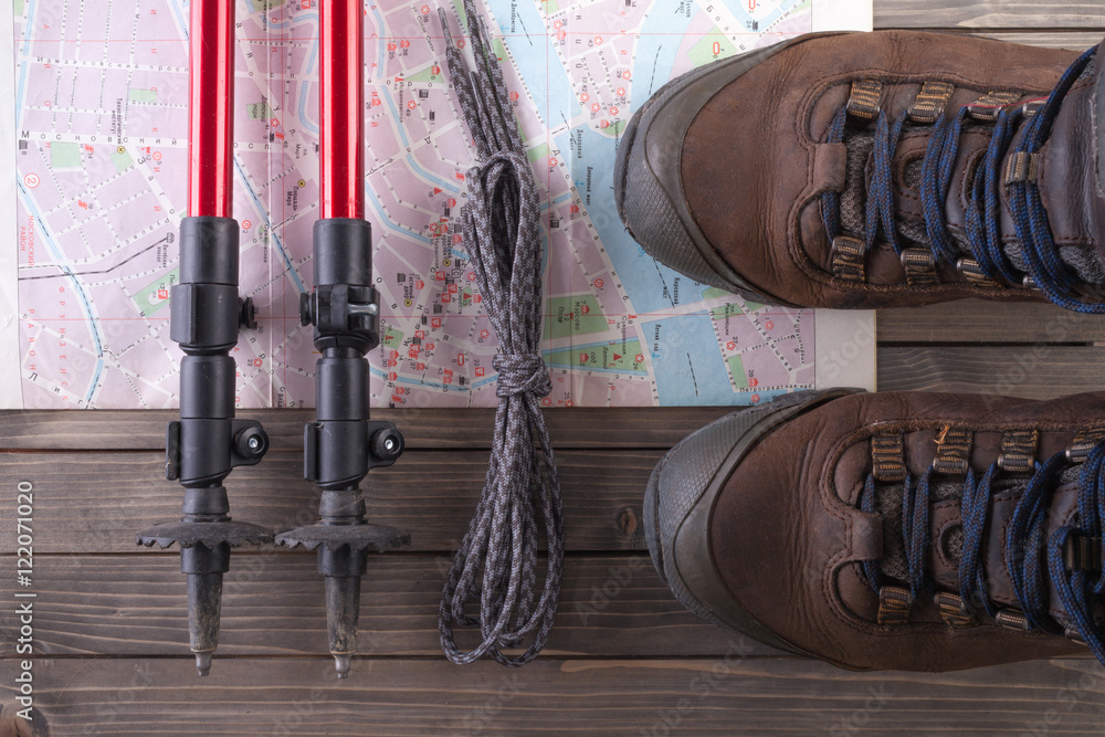 Equipment for hiking on a wooden floor background.