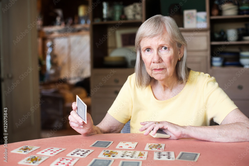Fototapeta premium Woman holding playing card at table