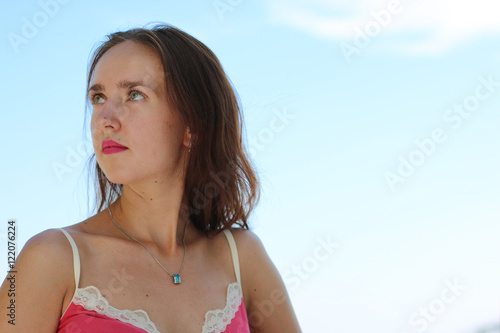 Portrait of a young woman against a background of clouds