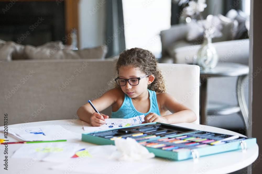 Girl coloring with felt tip pen on paper at table Girl coloring with felt tip pen on paper at table