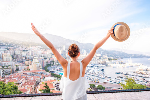 Young female traveler enjoying great view on the city with harbor in Monte Carlo in Monaco