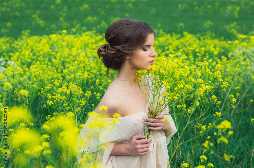 Portrait of young beautiful girl in field with bouquet of yellow flowers in hands, profile Portrait of young beautiful girl in field with bouquet of yellow flowers in hands, profile