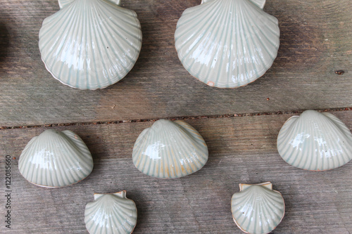 white clay scallop shells against a plain wooden background