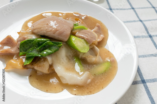 Rad Na, Famous Thai Chinese style wide rice noodle dish with tasty tender pork with thick gravy sauce. close up