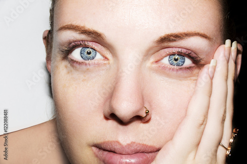 Young blue eyes woman touching her face