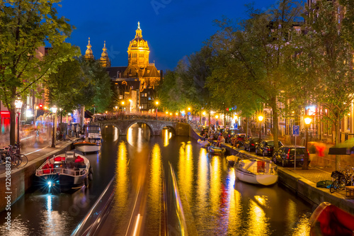 Night red-light district De Wallen  canal  Basilica of Saint Nicholas and bridge  Amsterdam  Holland  Netherlands. Long exposure.