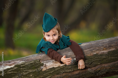 Fototapeta Naklejka Na Ścianę i Meble -  A young boy dressed up as Robin Hood playing in the forest