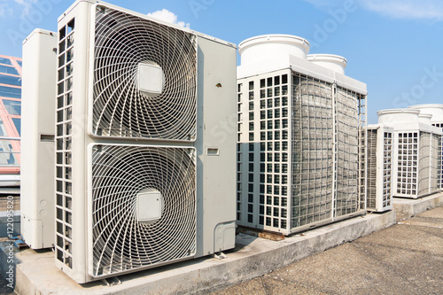 Industrial air conditioner condensers (outside unit) on the roof of a building on a hot summer day photo