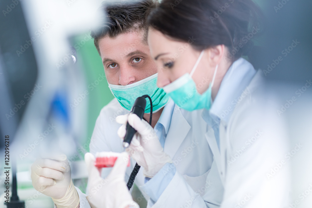 Dental prosthesis, dentures, prosthetics work. Dental students while working on the denture, false teeth, a study and a table with dental tools. Dental prosthesis, dentures, prosthetics work. Dental students while working on the denture, false teeth, a study and a table with dental tools.