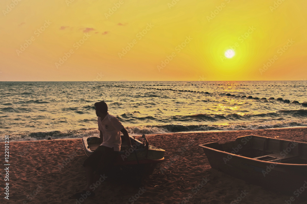 man sit on boat looking sunset beach