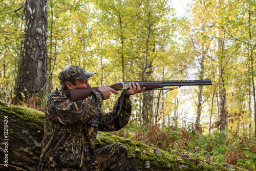Hunter with a gun in the autumn woods, hunting for a hazel grouse
 photo