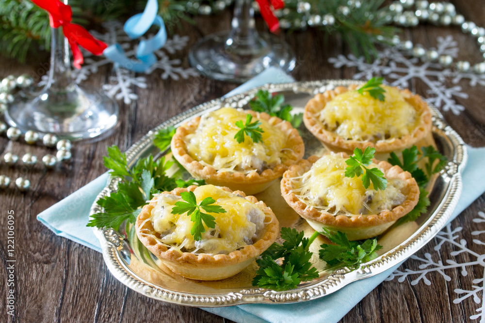 Holiday appetizer: tartlets with mushrooms and meat on a celebra Holiday appetizer: tartlets with mushrooms and meat on a celebra