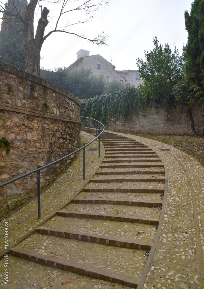 Spoleto (Italy) - A misty fall day in the charming medieval village in Umbria region. The soft focus depends on dense fog, which, however, creates an evocative atmosphere with Sun rays 