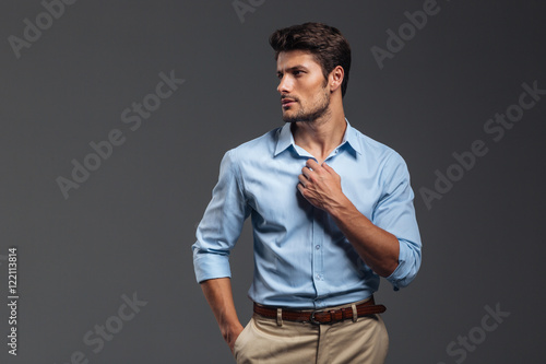 Foto Portrait of a casualman buttoning his shirt isolated