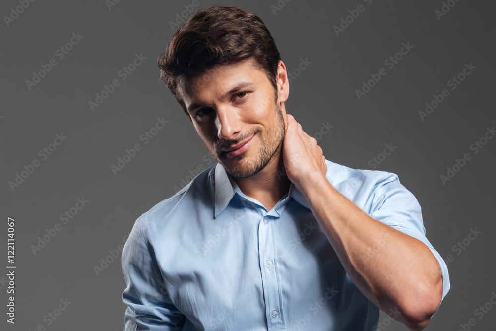 Fototapeta premium Pensive smiling handsome businessman in white shirt looking at camera