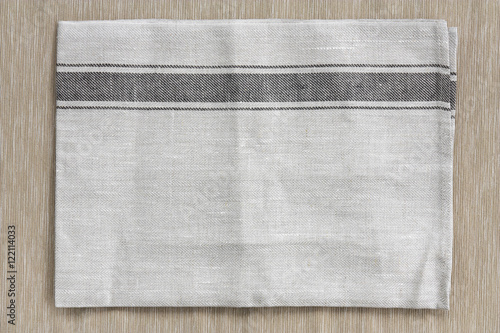 top view blank gray plate mat (napery) or dish towel on brown ta