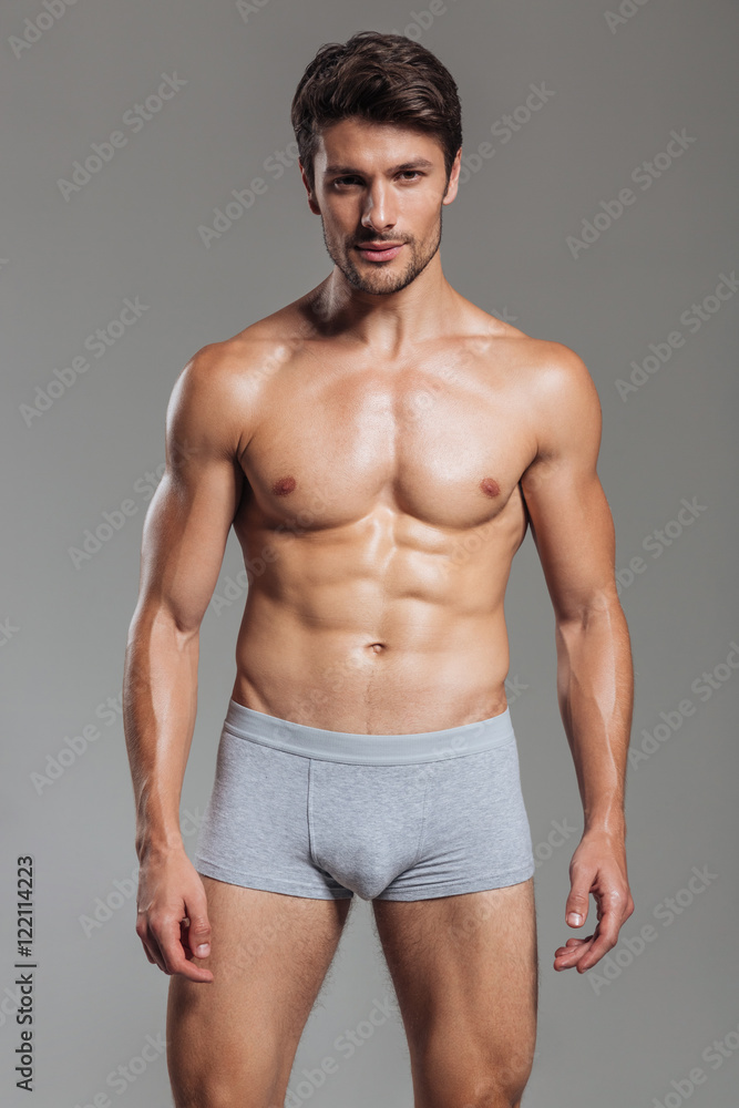 Portrait of a happy muscular man in underwear standing
