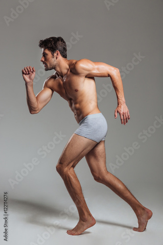 Portrait of a confident naked athletic man in underwear posing