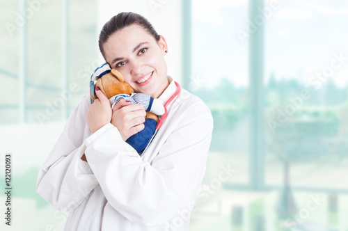 Trustworthy pediatrician hugging plush toy