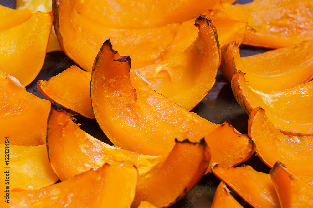 Slices of roasted pumpkin with honey on background the oven pan Slices of roasted pumpkin with honey on background the oven pan