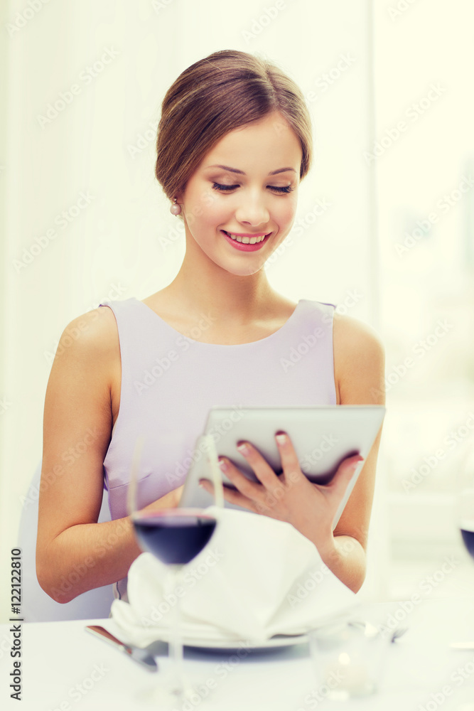 smiling woman with tablet pc computer at resturant smiling woman with tablet pc computer at resturant