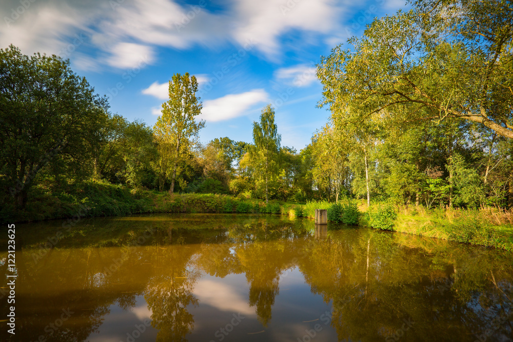 A small pond in the summer landscape. Czech republic.