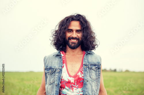 Fotografie smiling young hippie man on green field