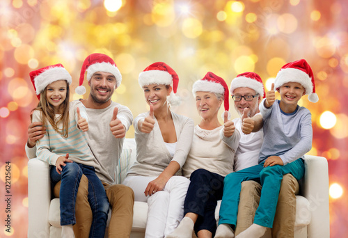 happy family in santa hats showing thumbs up