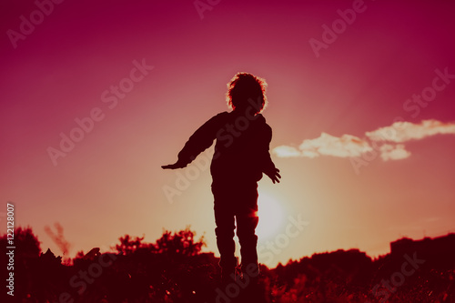 little boy jumping from joy in sunset nature