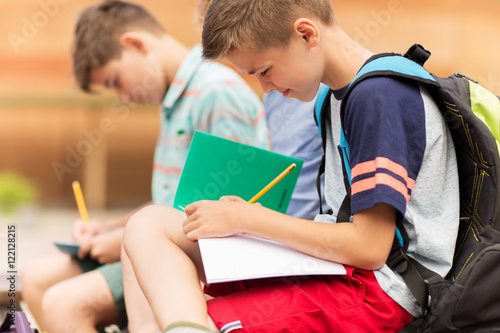 elementary school students writing to notebooks