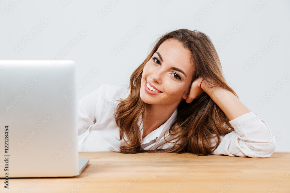 Cheerful young beautiful woman sitting at the desk with laptop Cheerful young beautiful woman sitting at the desk with laptop
